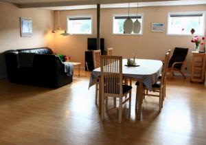 uma sala de estar com uma mesa e cadeiras e um sofá em Den gamle stald em Ovtrup
