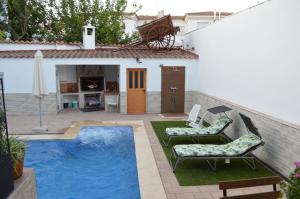 un patio trasero con piscina y una casa en Casa Rural Los Pinillos, en Motilleja