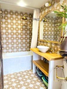 a bathroom with a sink and a tub and a mirror at Superbe & lumineux avec balcon! Quartier parisien animé in Paris