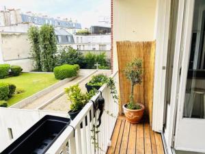 a balcony with two potted plants on a house at Superbe & lumineux avec balcon! Quartier parisien animé in Paris