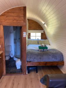 霍利韋爾的住宿－Acorns Luxury Glamping，一间小房间的卧室,配有一张床铺