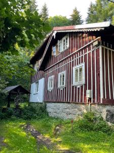 ein rotes und weißes Haus in der Unterkunft Roubenka u potoka Jizerské hory in Desná