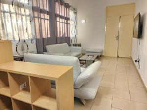 - un salon avec un canapé et une table dans l'établissement KADIDJA APARTMENTS & SUITES Akodessewa, à Lomé