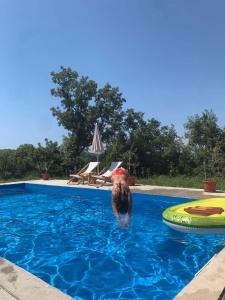 a person in a red hat in a swimming pool at Guesthouse P&A in Budva