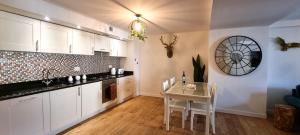 a kitchen with white cabinets and a table with chairs at LOCH NESS - Luxury Highland Retreat in Scotland in Fort Augustus