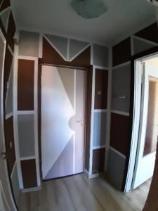 a hallway with a white door and a window at Independent apartment in varena in Varėna
