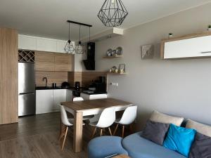 eine Küche und ein Wohnzimmer mit einem Tisch und Stühlen in der Unterkunft M&M Apartament Glogera in Krakau