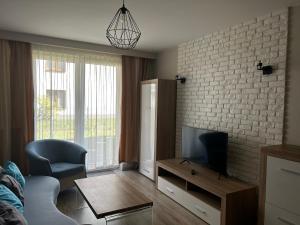 ein Wohnzimmer mit einem Flachbild-TV und einem Sofa in der Unterkunft M&M Apartament Glogera in Krakau