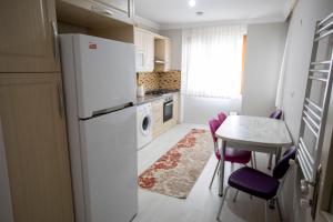 a kitchen with a refrigerator and a table with purple chairs at Korkmaz Apart in Trabzon