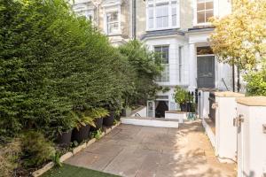 een huis met een binnenplaats met planten ervoor bij Superior 5* Kensington, London Flat + Free Wi-Fi in Londen
