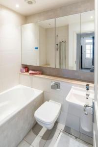 een badkamer met een toilet, een bad en een wastafel bij Superior 5* Kensington, London Flat + Free Wi-Fi in Londen