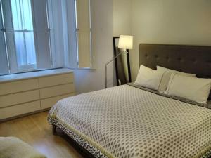 een slaapkamer met een bed, een lamp en een raam bij Superior 5* Kensington, London Flat + Free Wi-Fi in Londen