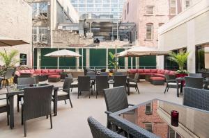 un patio al aire libre con sillas, mesas y sombrillas en Hampton Inn & Suites Chicago-Downtown, en Chicago