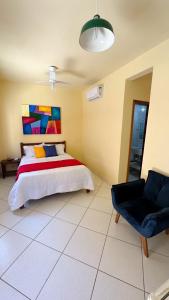 a bedroom with a bed and a chair in it at Pousada Antares de Paraty in Paraty