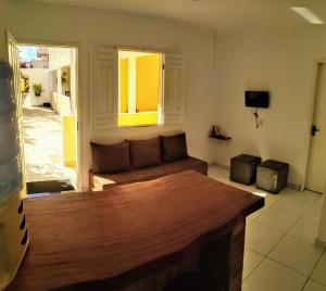 a living room with a wooden couch in a room at O Pouso Condomínio in Mucugê
