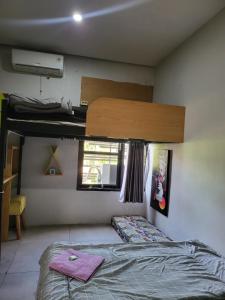 1 dormitorio con litera y toallas rosas. en Happy House BnB Bromo backpacker en Probolinggo