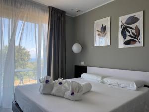 a bedroom with a bed with white sheets and a window at Aurantia - Mediterranean Tale in Tropea