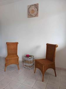 two wicker chairs and a basket on a tile floor at Bosofet Beach and Creek Lodge in Sanyang
