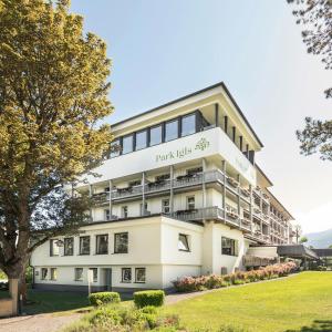 ein großes weißes Gebäude mit einem Parkanzeichen drauf in der Unterkunft Park Igls - Medical Spa Resort in Innsbruck