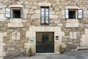 a stone building with a door and two windows at Casa Grande de Cristosende in Cristosende