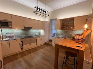 a large kitchen with a wooden table and a counter at The Annex at Merley Mews in Poole