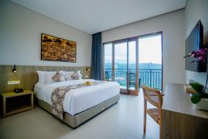 MenangaにあるTapa Agung Viewのベッドとバルコニー付きのホテルルーム