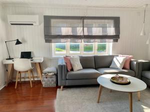 ein Wohnzimmer mit einem Sofa und einem Tisch in der Unterkunft NorSpan Lodge - Lofoten with Seaview in Stamsund