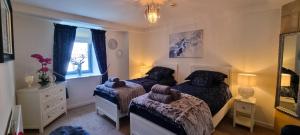 a bedroom with two beds and a mirror at LOCH NESS - Luxury Highland Retreat in Scotland in Fort Augustus +36 photos