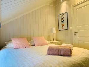 a bedroom with a bed with two pink pillows at NorSpan Lodge - Lofoten with Seaview in Stamsund