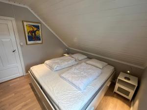 een klein bed met witte lakens in een kamer bij Måløy City Center - Château Kvalheim in Måløy