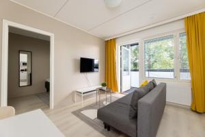 a living room with a couch and a tv at Hiisi Homes Riihimäki in Riihimäki