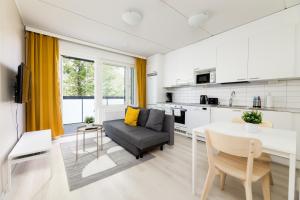 a kitchen and living room with a table and a couch at Hiisi Homes Riihimäki in Riihimäki