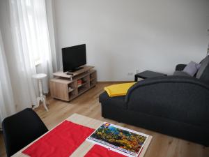 sala de estar con sofá y TV en Jaekels Ferienwohnung en Görlitz