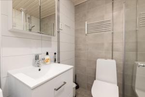a bathroom with a toilet and a sink and a mirror at Hiisi Homes Riihimäki in Riihimäki +28 photos