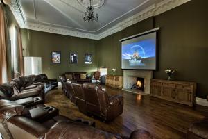 sala de estar con muebles de cuero y TV de pantalla plana en Glentworth Hall by Group Retreats, en Glentworth