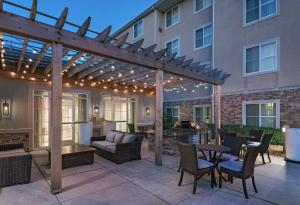 a patio with a pergola and tables and chairs at Homewood Suites by Hilton College Station in College Station