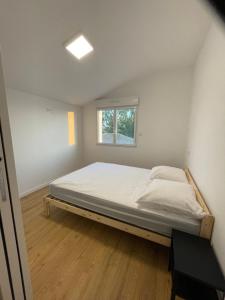 a bed in a room with a window at La maison d'Ilaude de 7 à 14 personnes in Talmont-Saint-Hilaire
