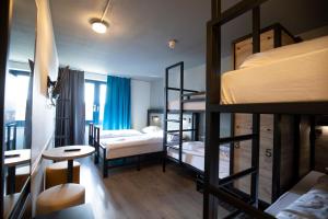 a room with three bunk beds and a table at a&o Rotterdam City in Rotterdam