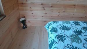een kamer met een bed in een kamer met houten wanden bij Glamping Fluffy Horns - Glempings Pūkainie Ragi in Plieņciems