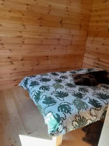 un perro acostado en una cama en una habitación en Glamping Fluffy Horns - Glempings Pūkainie Ragi en Plieņciems