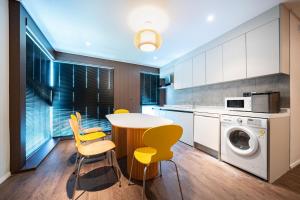 a kitchen with a table and chairs and a washing machine at Cloud in Hotel Mokpo Peace Square in Mokpo