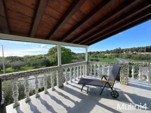 una silla en el balcón de una casa con vistas en Vala Apartments - Helvetia Rovinj en Rovinj