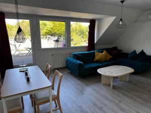 ein Wohnzimmer mit einem blauen Sofa und einem Tisch in der Unterkunft A&V Apartments Wunderschöne Rheinblick Wohnung zum entspannen in Duisburg