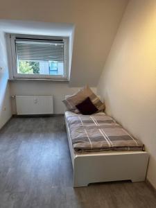 ein kleines Bett in einem Zimmer mit Fenster in der Unterkunft A&V Apartments Wunderschöne Rheinblick Wohnung zum entspannen in Duisburg
