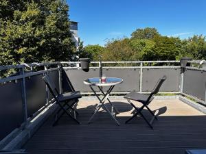 einen Tisch und zwei Stühle auf einem Balkon in der Unterkunft A&V Apartments Wunderschöne Rheinblick Wohnung zum entspannen in Duisburg