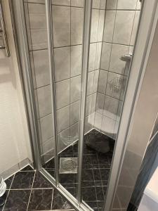 um chuveiro com uma porta de vidro na casa de banho em Måløy City Center - Château Kvalheim em Maloy