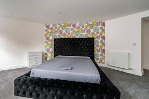 a bedroom with a bed with a black head board at Modern 3BHK near Edinburgh zoo in Edinburgh