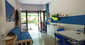 una cucina e una sala da pranzo con tavolo e sedie blu di Residence Pineda A 6 a Bibione