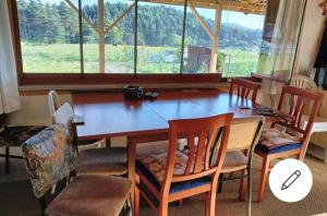 mesa de comedor con sillas y ventana grande en Bolu dağ evi at yaylası, 
