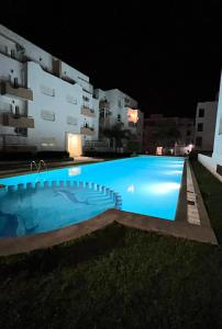 una piscina frente a un edificio por la noche en The PEARL of ACHAKAR , your 5 STAR cozy apartment en Tánger